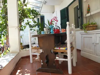a porch with a wooden table and a chair at DaRiMaPa House in Mondello