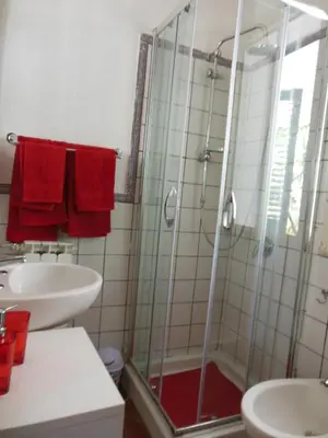 a bathroom with a glass shower and a sink at DaRiMaPa House in Mondello