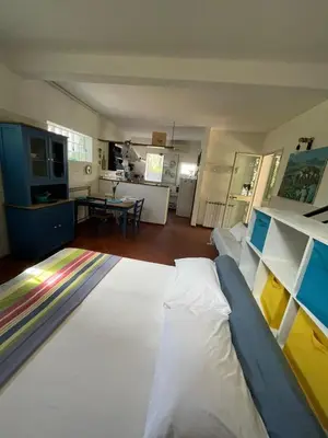 a living room with a large bed and a kitchen at DaRiMaPa House in Mondello