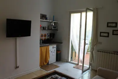 a living room with a television and a kitchen at DaRiMaPa House in Mondello