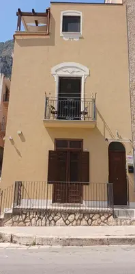 a building with a balcony and a window at DE MEO Guest House in Castellammare del Golfo