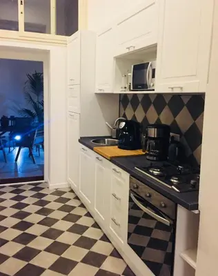 a kitchen with white cabinets and a checkered floor at CLUVERIO11 LUXURY APARTMENT in Palermo