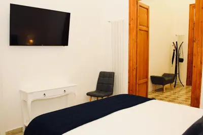 a bedroom with a bed and a tv on the wall at CLUVERIO11 LUXURY APARTMENT in Palermo