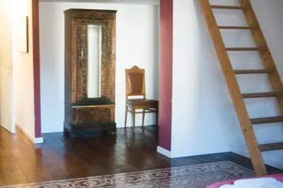 a hallway with a staircase and a mirror and a chair at 90100 in Palermo