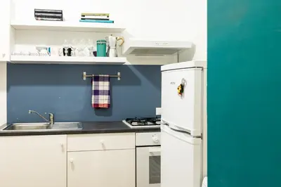 a kitchen with a white refrigerator and a sink at 90100 in Palermo
