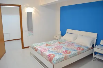 a bedroom with a bed with a blue wall at Casa DahLia Mondello in Mondello