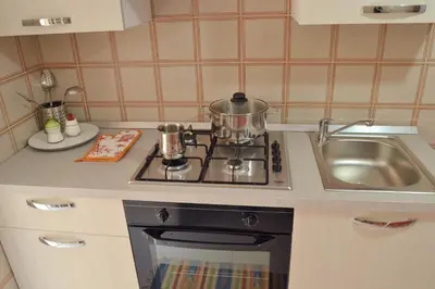 a kitchen with a stove and a sink at Casa DahLia Mondello in Mondello