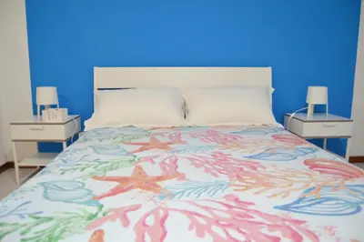 a bedroom with a bed with a blue wall at Casa DahLia Mondello in Mondello