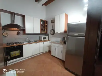 a kitchen with white cabinets and a stainless steel refrigerator at Villa Ancora in Campofelice di Roccella