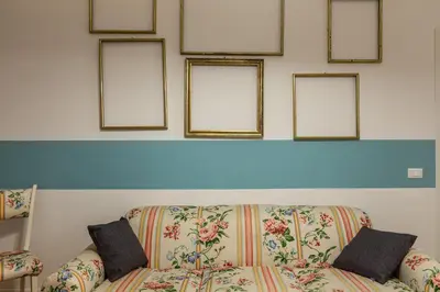 a couch in a room with four pictures on the wall at Casetta Allegra in Palermo