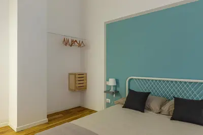 a bedroom with a bed with a blue headboard at Casetta Allegra in Palermo