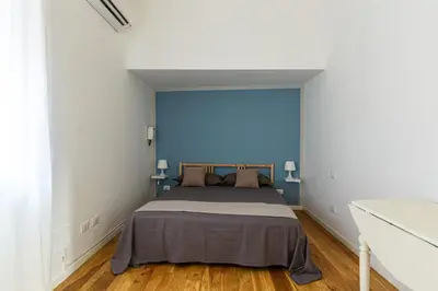 a bedroom with a bed with a blue wall at Casetta Allegra in Palermo