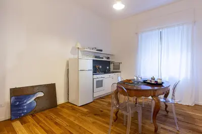 a dining room with a table and a refrigerator at Casetta Allegra in Palermo