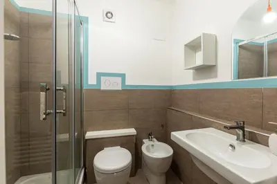 a bathroom with a toilet and a sink and a shower at Casetta Allegra in Palermo