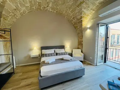 a bedroom with a bed and a brick wall at Appartamento Valverde in Palermo