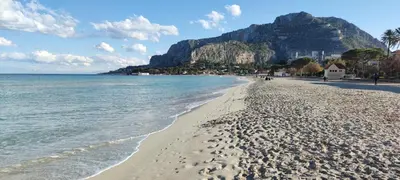 a view of a beach with a mountain in the background at Beach House Mondello in Mondello