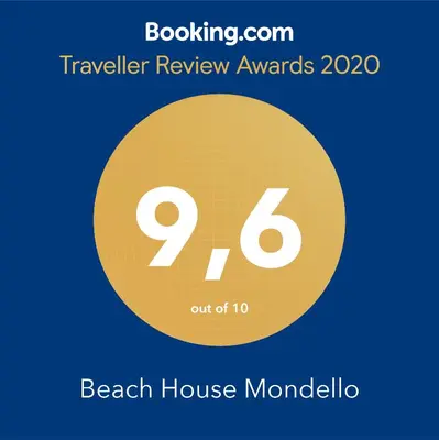 a sign that says beach house mondello with a yellow circle at Beach House Mondello in Mondello