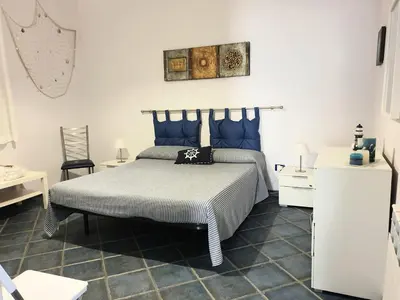 a bedroom with a bed with blue pillows at Casa Maro' in Palermo