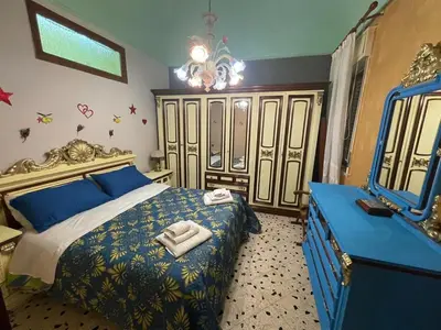 a bedroom with a blue bed and a mirror at Big Mom House in Palermo