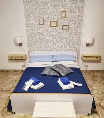 a bed with blue sheets and utensils on it at Alter Ego in Lascari