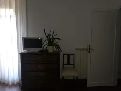 a bedroom with a dresser with a television and a chair at La stanza di Angi a Mondello in Palermo