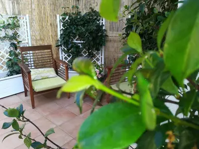 a patio with two chairs and some plants at La stanza di Angi a Mondello in Palermo