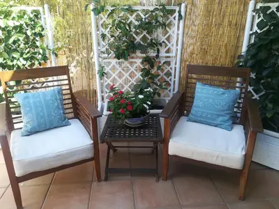 two chairs and a table with a potted plant on a patio at La stanza di Angi a Mondello in Palermo