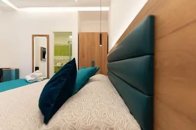 a bedroom with a large bed with blue pillows at Room & Breakfast Aloe in San Vito lo Capo