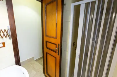 a bathroom with a toilet and a wooden door at GuestHost - Palermo Functional Studio in Palermo