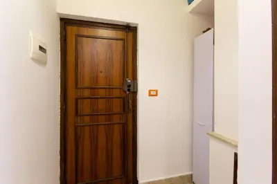 a brown wooden door in a white room at GuestHost - Palermo Functional Studio in Palermo