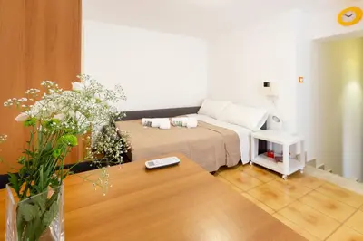 a room with a bed and a table with flowers at GuestHost - Palermo Functional Studio in Palermo