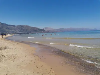 a beach with a group of people in the water at Casa Vacanze Aurora Boreale in Alcamo Marina