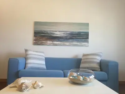 a living room with a blue couch and a bowl on a table at Casa Vacanze Aurora Boreale in Alcamo Marina