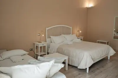 a bedroom with two beds with white sheets and tables at B&B Matteo Bonello - Fianco Cattedrale in Palermo