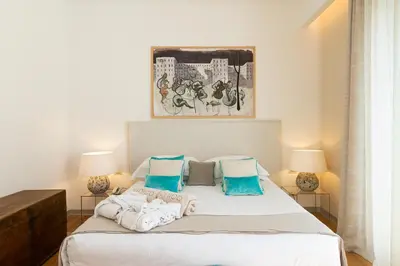 a bedroom with a large bed with two lamps at Unìco Boutique Hotel d'Arte in Mondello