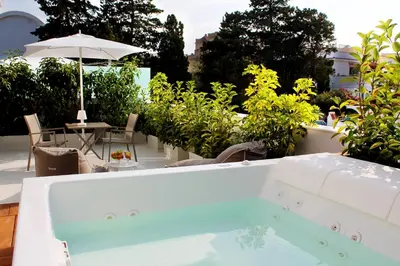 a pool on a patio with a table and an umbrella at Unìco Boutique Hotel d'Arte in Mondello