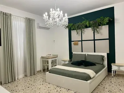 a bedroom with a bed and a chandelier at Cappuccini Green Relax in Carini