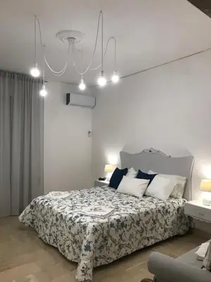 a bedroom with a bed and a chandelier at Cappuccini Green Relax in Carini