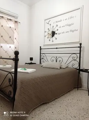a bedroom with a bed with a poster on the wall at Cappuccini Green Relax in Carini