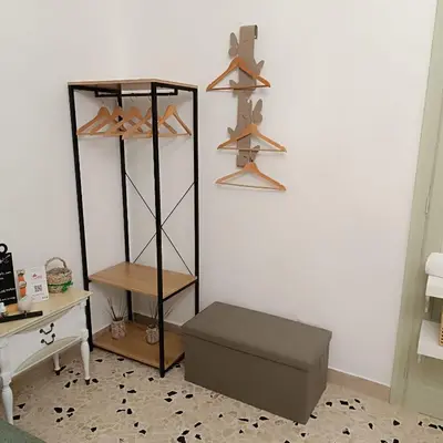 a room with a shelf with hangers and a box at Cappuccini Green Relax in Carini