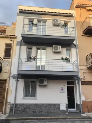 a tall white building with balconies and windows at Le Tre Rose in Terrasini