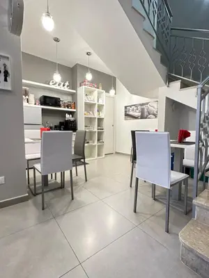 a dining room with white chairs and a table at Le Tre Rose in Terrasini