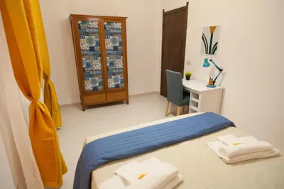 a bedroom with a bed and a desk and a chair at Casa Benzo in Palermo