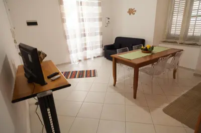 a living room with a dining room table and a television at Casa Benzo in Palermo