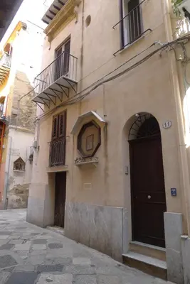 a building with a black door and a balcony at Casa Benzo in Palermo