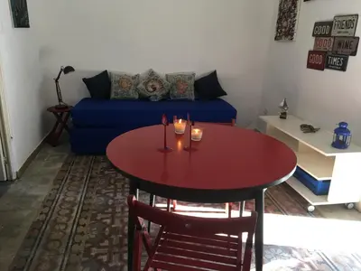 a living room with a table and a blue couch at Al Baglio low cost in Palermo
