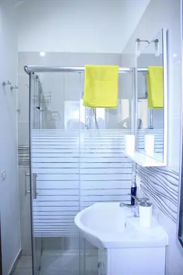 a bathroom with a sink and a shower with yellow towels at B&B d'Orleans in Palermo