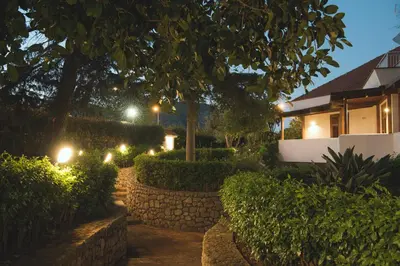 a garden at night with a stone wall and lights at Il Giardino di Venere in Mondello