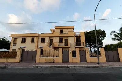 a yellow house on the side of a street at ZE-VI HOME in Santa Flavia