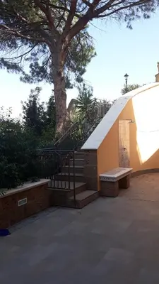 a staircase with a bench next to a tree at ZE-VI HOME in Santa Flavia